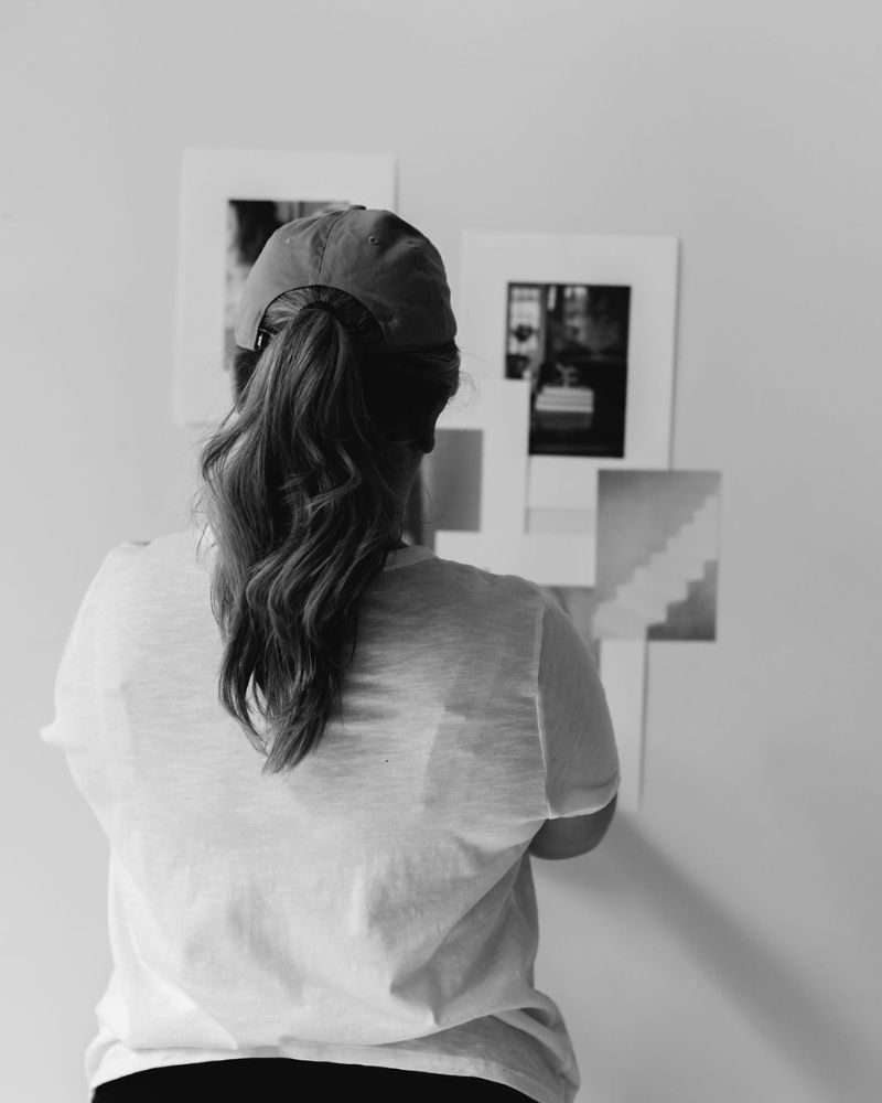 woman in baseball hat and ponytail working on collage